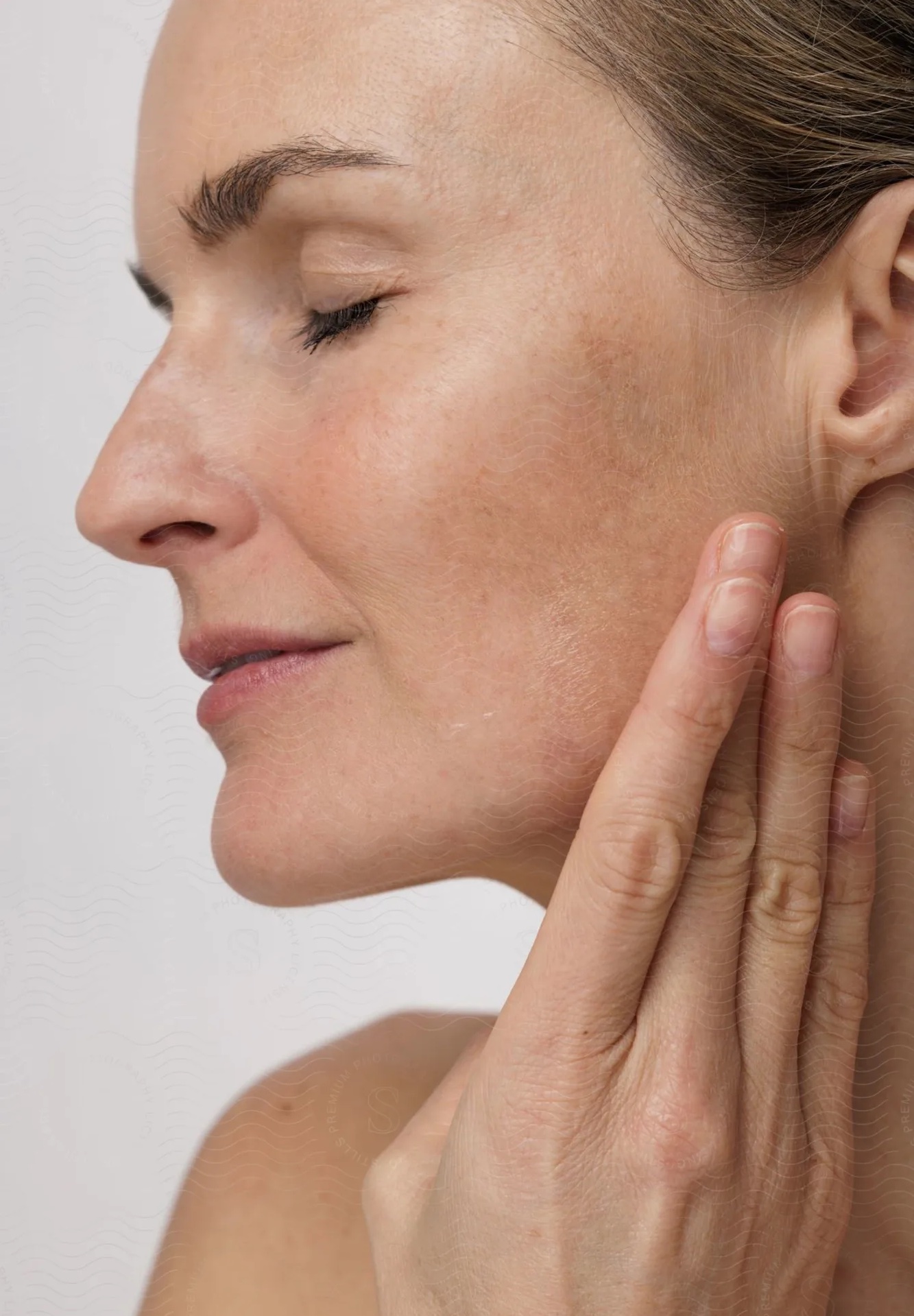 stills_369221_sigrid-mayer (1) copie – copie Femme d'âge mur vue de profil, cheveux attachés et se tenant le visage avec sa main